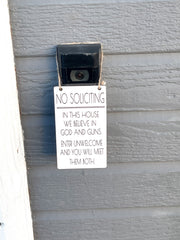 No soliciting / In this house we believe in God and guns. Enter unwelcome and you will meet them both / Protective hanging doorbell sign