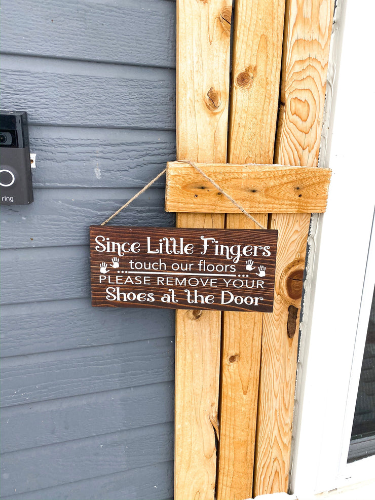 Since little fingers touch our floors please remove your shoes at the door wooden front door sign hung with twine. Remove your shoes sign