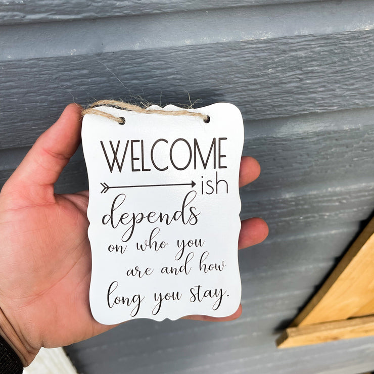 Welcome - ish. Depends on who you are and how long you stay. Small engraved entryway door sign. Front door, porch, patio small welcome sign