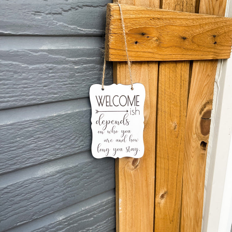 Welcome - ish. Depends on who you are and how long you stay. Small engraved entryway door sign. Front door, porch, patio small welcome sign